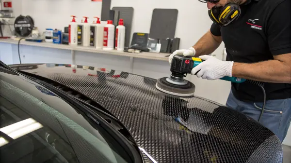 Side-by-side comparison of a sanded matte surface and a fully polished, mirror-shine carbon fiber part.